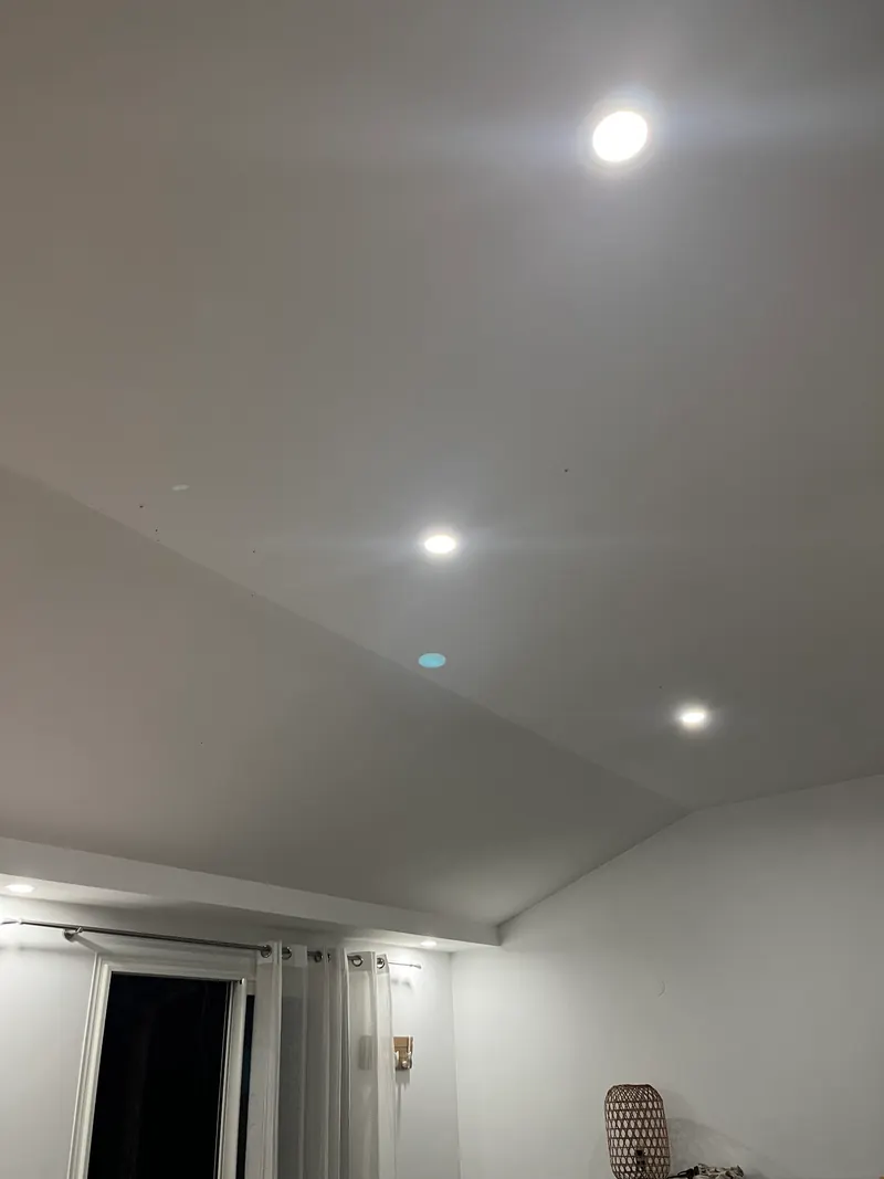 Un plafond blanc éclairé par des spots encastrés.